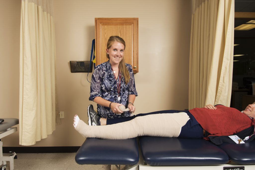 Therapist assisting lymphedema patient with bandage
