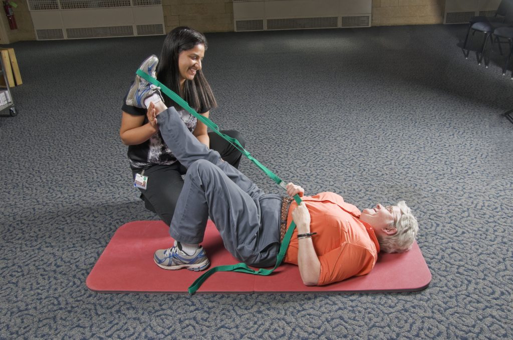 Physical therapist assisting patient with therapy exercise