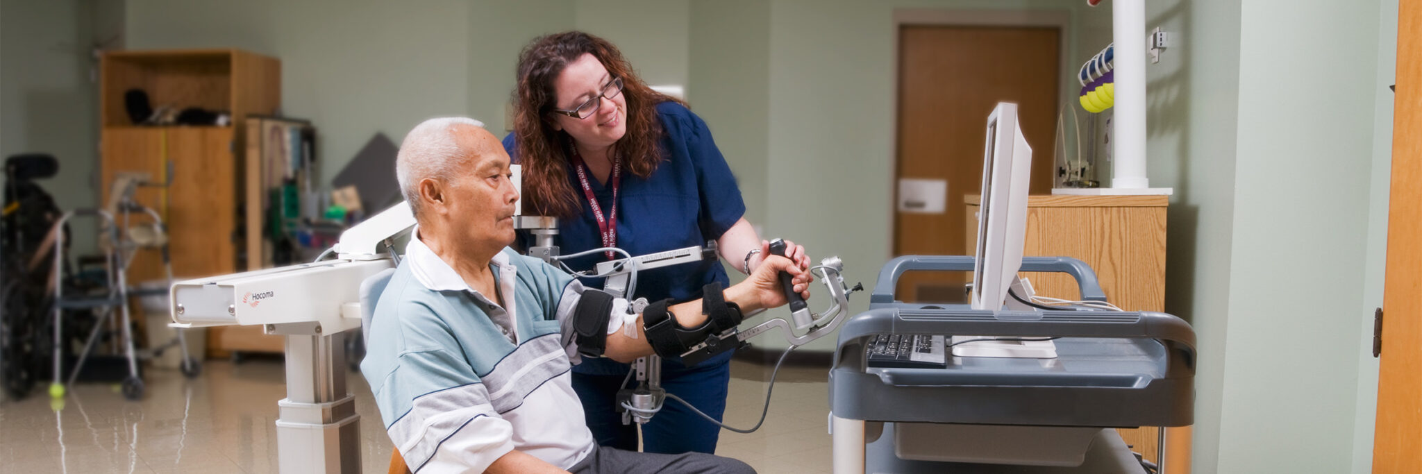 Male patient using Armeo Therapy with female Physical Therapist