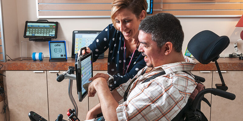 Man uses tablet to communicate with rehabilitation technology specialist