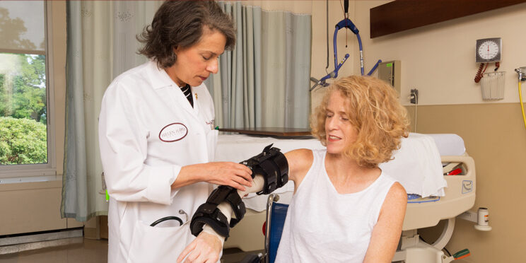 Specialist assisting patient with trauma rehabilitation equipment