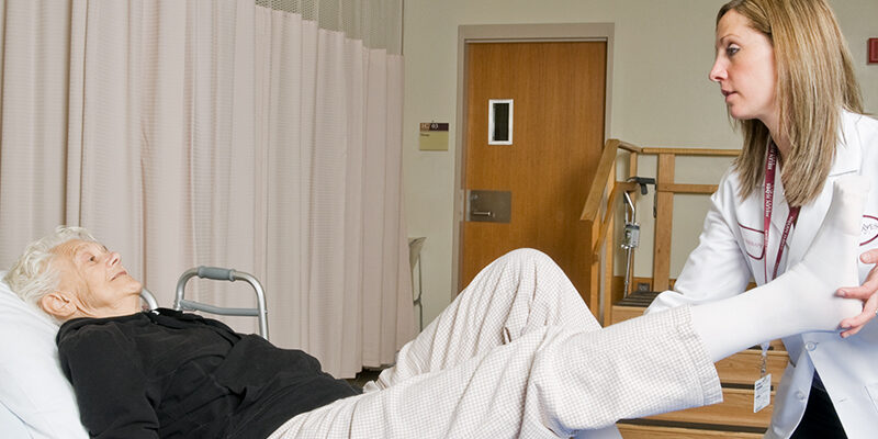 Therapist extending female patients leg during physical therapy