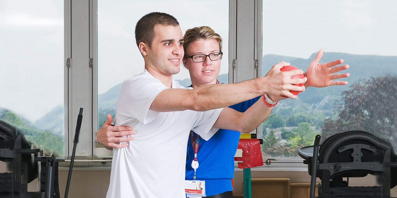Therapist assisting patient in traumatic brain injury rehabilitation exercise